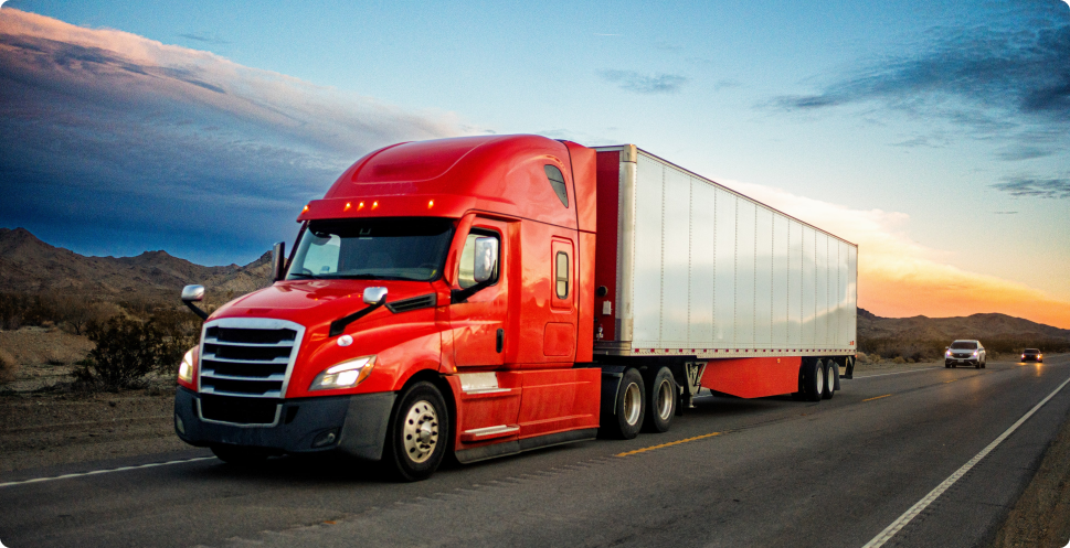 Red semi truck hauling freight in a dry van down the highway