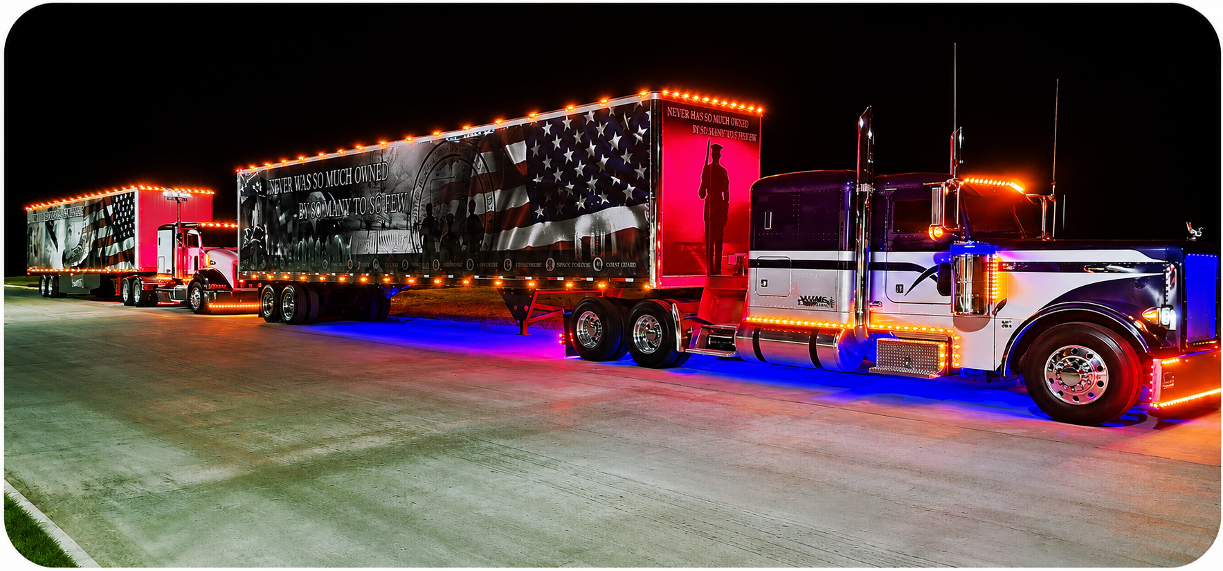 HVMC-Transportation Patriotic semi trucks illuminated with LED lights at night, featuring American flag-themed trailers honoring military service.