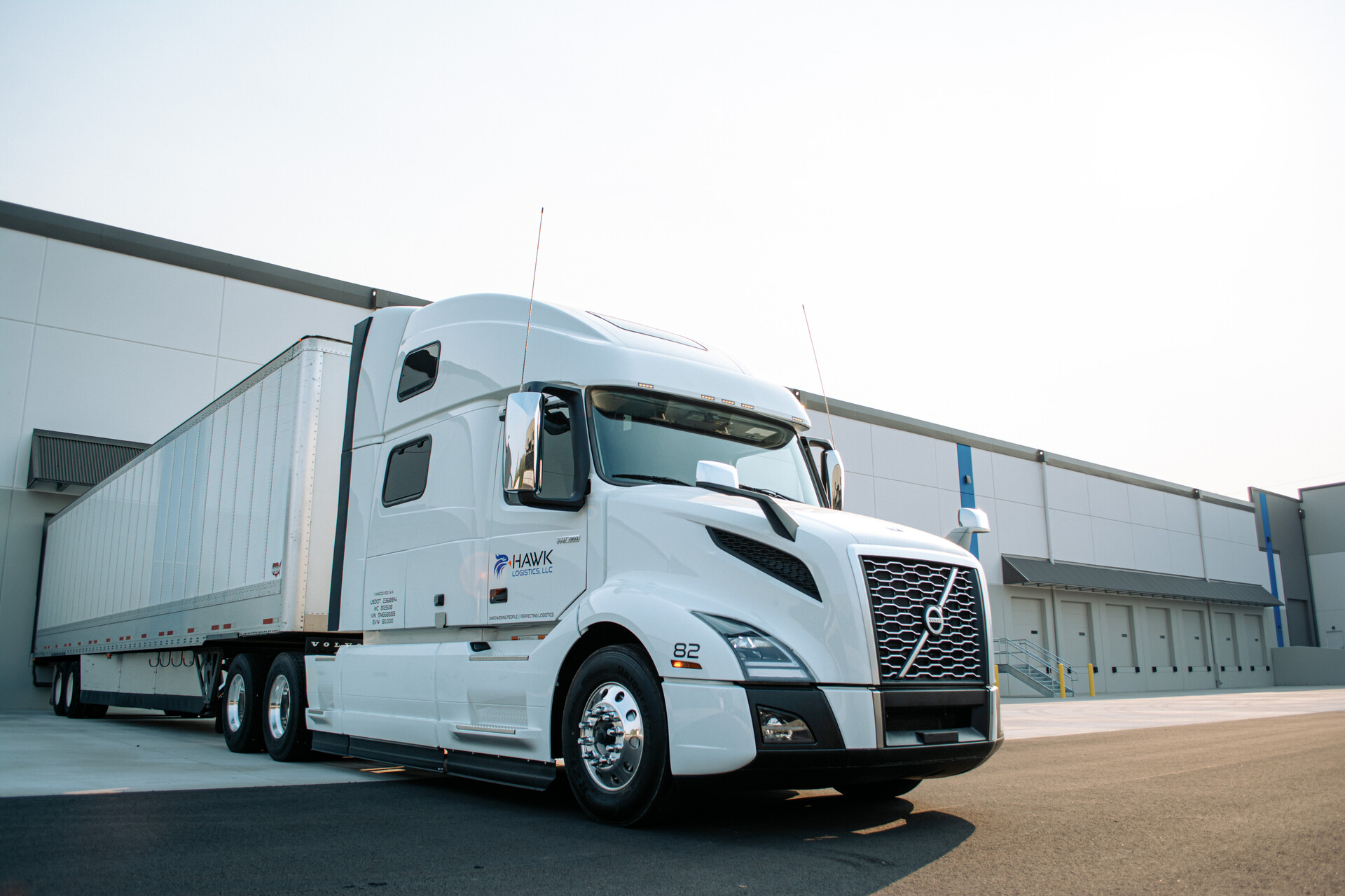 Hawk_Logistics1 Photo of a white Volvo 18-wheeler backed into a dock.